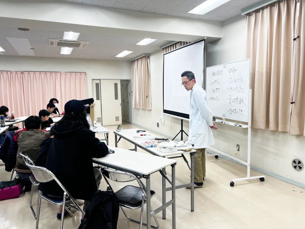 よーた先生がホワイトボードを使ってアリの体のつくりを解説するようす